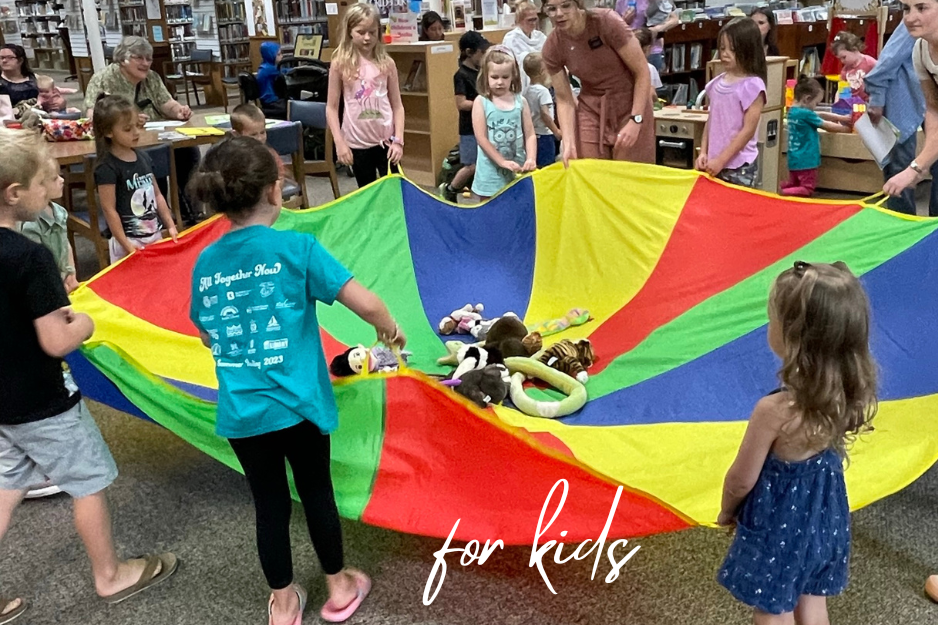 kids holding a colorful parachute in a circle